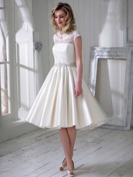 Nicola Anne Posie Tea length wedding dress with high neck lace bodice cal sleeves and plain skirt front view.