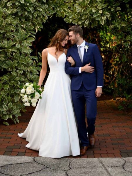 Essense of Australia D3080 plain sophisticated ballgown wedding dress with shoestring straps and V neck front view with groom.