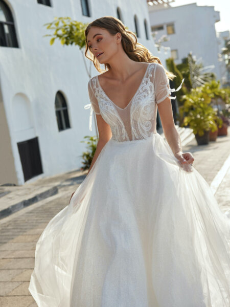 Libelle Bridal Halo V neck wedding dress with short tulle sleeves low V back and floaty A line skirt front.