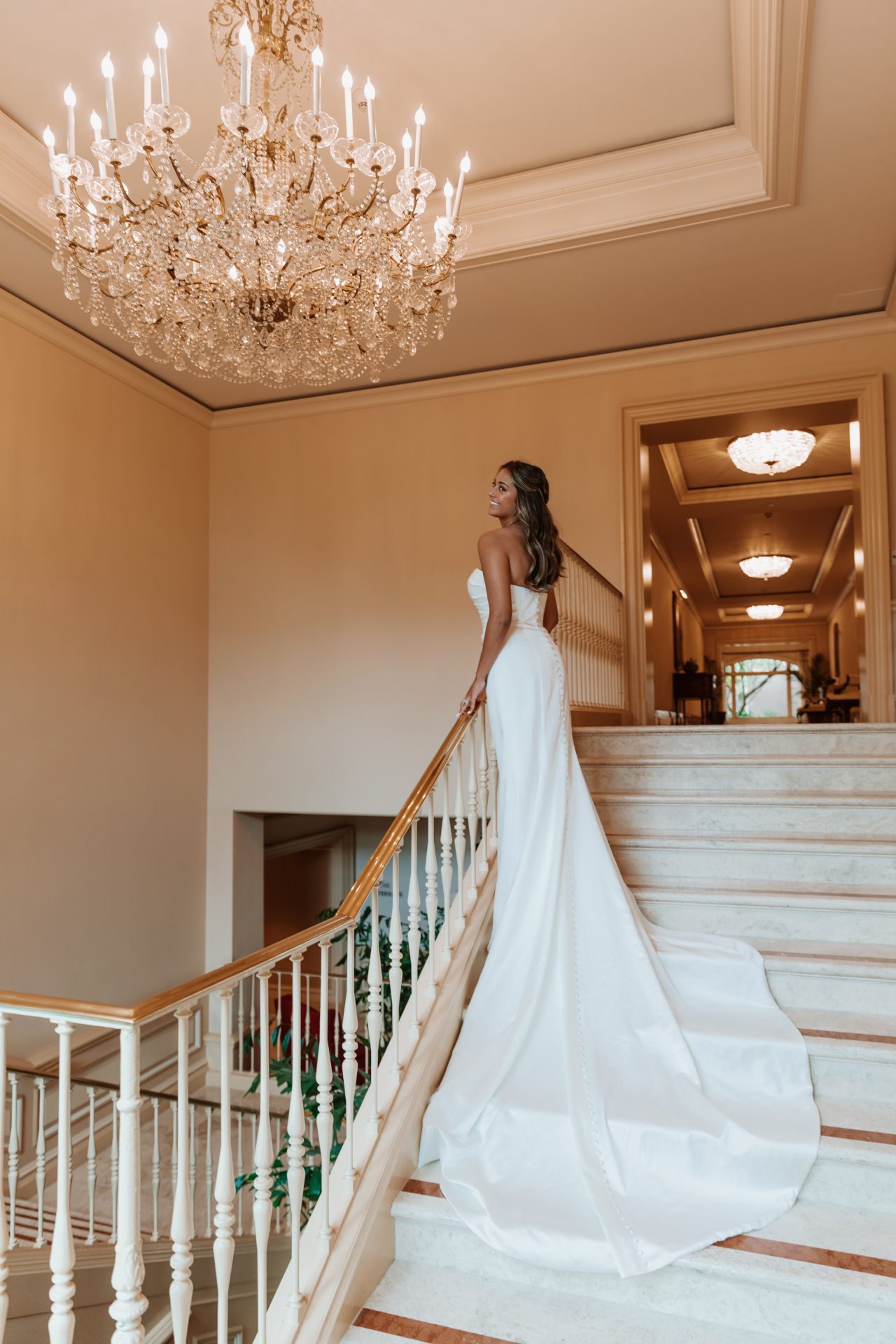 Essense of Australia D3705 plain satin fitted wedding dress on stairs showing train.
