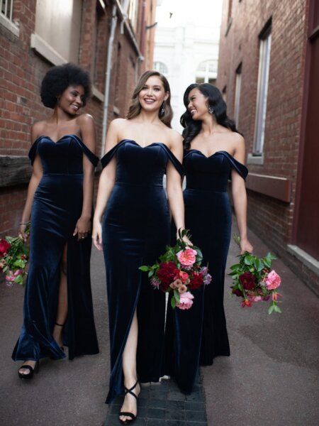 Luxurious Sorella Vita 9648 off the shoulder velvet bridesmaid dress with front split leg reveal group walking front view.
