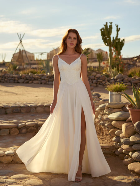 Herve Paris 10017500 Channa wedding dress with softly floating plain chiffon skirt with leg split and V neck bodice with subtle lace shimmer detail front view walking.