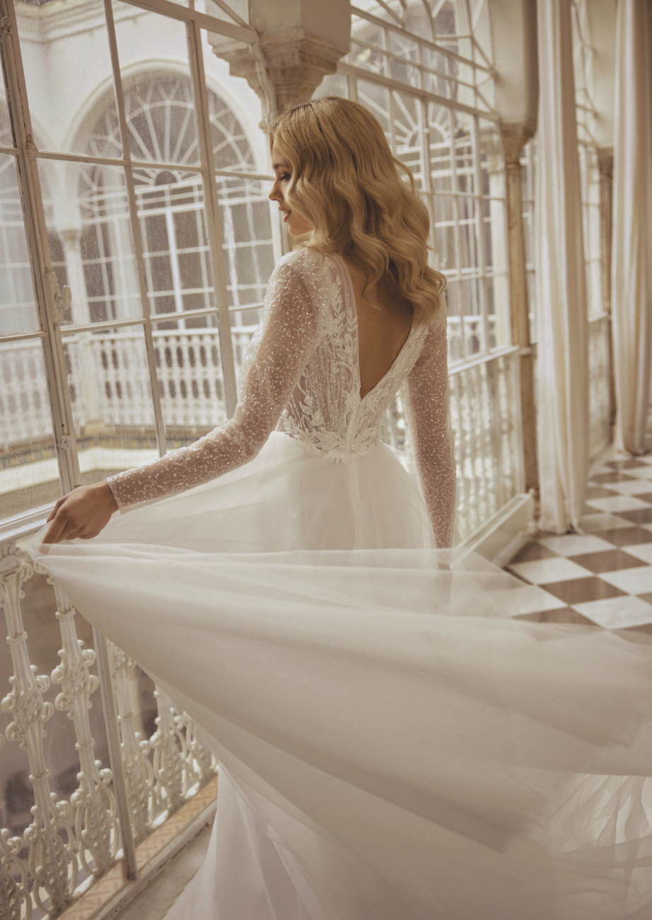 Libelle Bridal Jaleesa A line wedding dress with plunge V neckline long sleeves sparkle bodice back close up view.