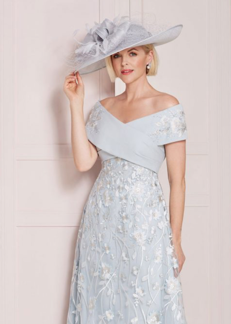 John Charles 66529 mother of the bride A line dress in pale blue floral lace and beaded Bardot neckline close up front view with hat.