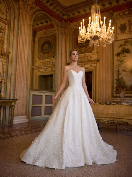 Randy Fenoli Ivy wedding dress with plain basque bodice optional drop drape sleeves and trailing leafy lace over an A-line skirt strapless front view.