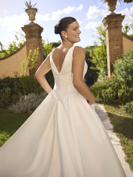 Modeca Curve Collection Janneka plus size plain wedding dress with boned basque drop waist bodice curved V neckline mid width straps and ballgown skirt close up back.