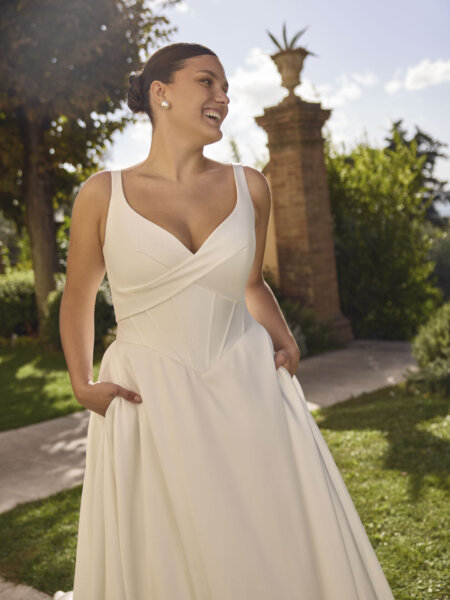 Modeca Curve Collection Janneka plus size plain wedding dress with boned basque drop waist bodice curved V neckline mid width straps and ballgown skirt close up front.