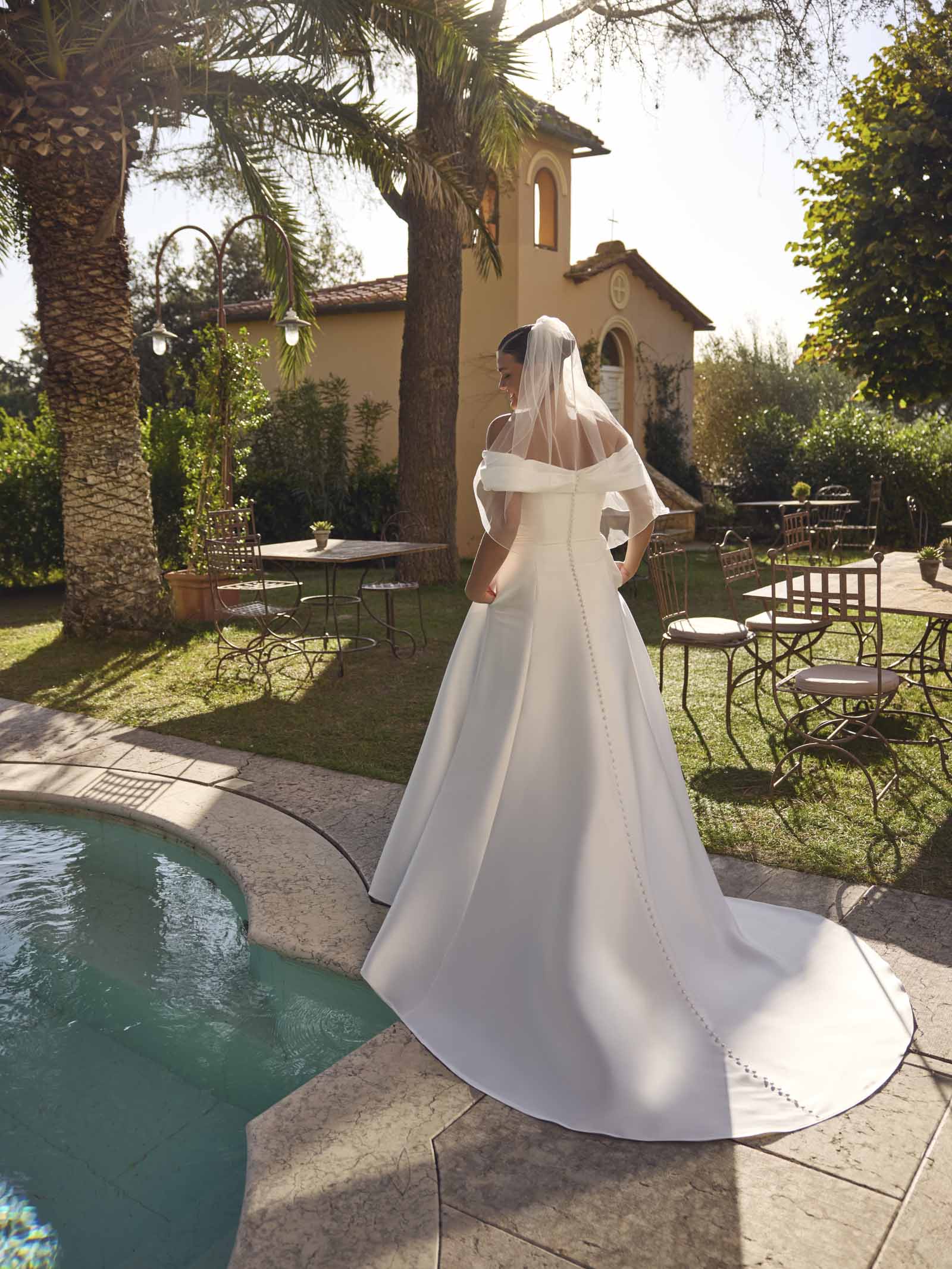 Modeca Curve collection Jolie pluse size A line wedding dress in plain mikado with off the shoulder rouched bodice and simple A line skirt full length back view.