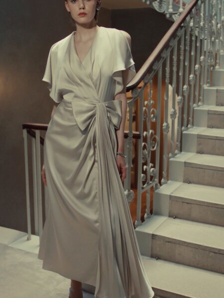 Maisonel 3116 pastel green mother of the bride dress with V neckline flutter sleeves and statement bowModern, elegant occasion wear for weddings, the races, cruises and black tie events front view with videomatching hats, shoes and bags available. 