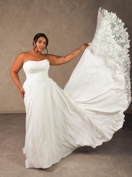 Essense of Australia D4504 Aline wedding dress in plain liquid crepe with some lace detail front view holding train.