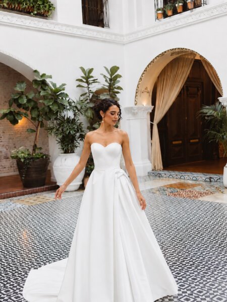 Essense of Australia D4566A plain ballgown with pick up skirt at the hip. This dress has an option to be made with high neckline and long sleeves in lace front view.