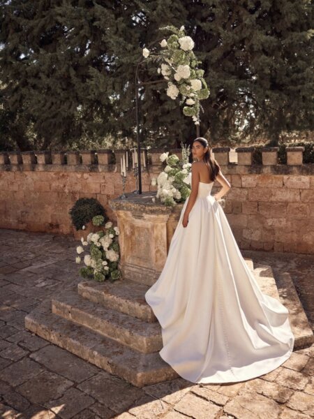 Modeca bridal Maranda ballgown wedding dress with optional bow and box pleats back view.