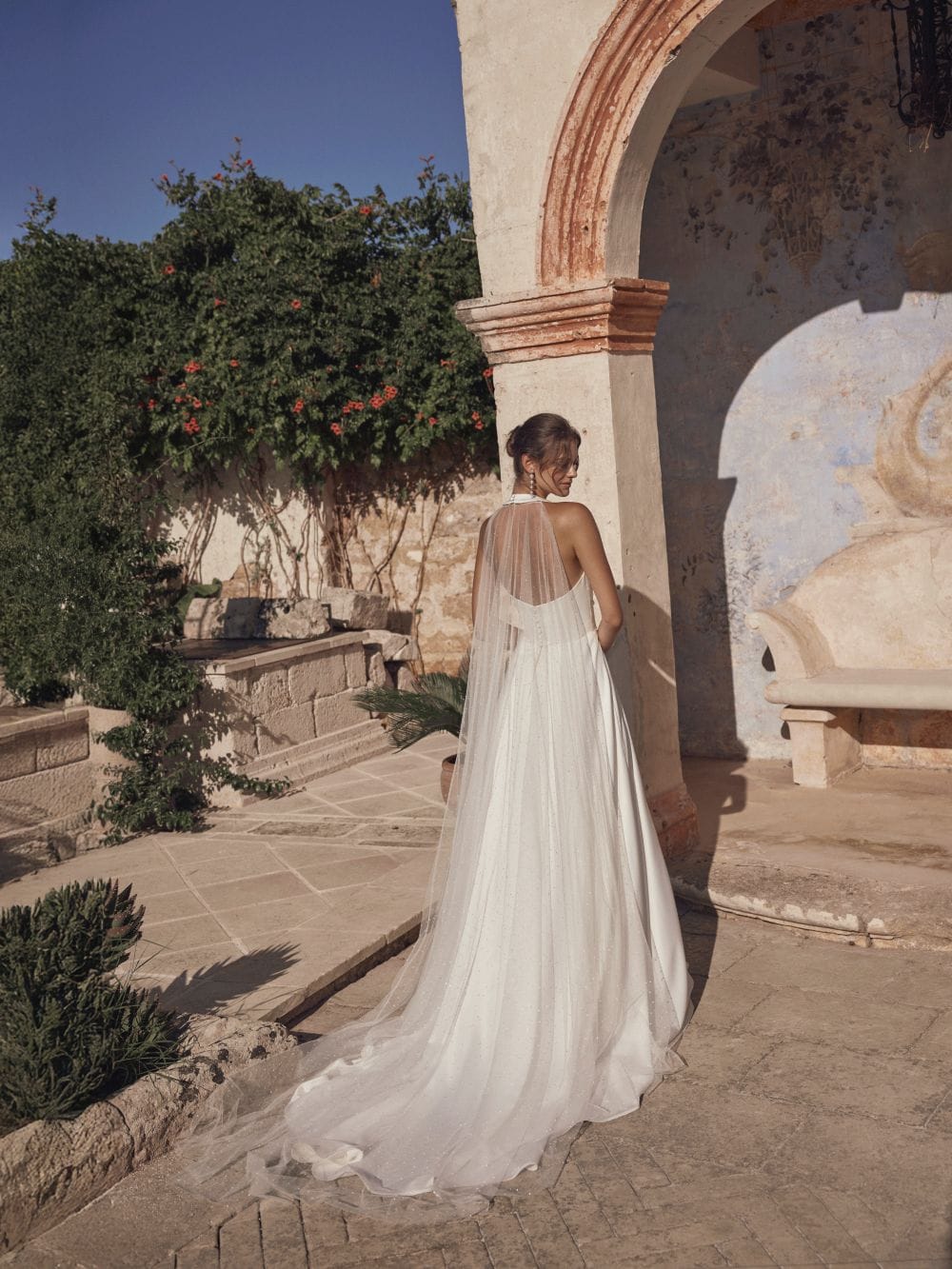 Modeca Bridal Milora halter neck wedding dress with A line skirt and optional tulle train perfect for weddings abroad back view.