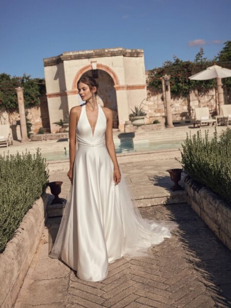 Modeca Bridal Milora halter neck wedding dress with A line skirt and optional tulle train perfect for weddings abroad front view.
