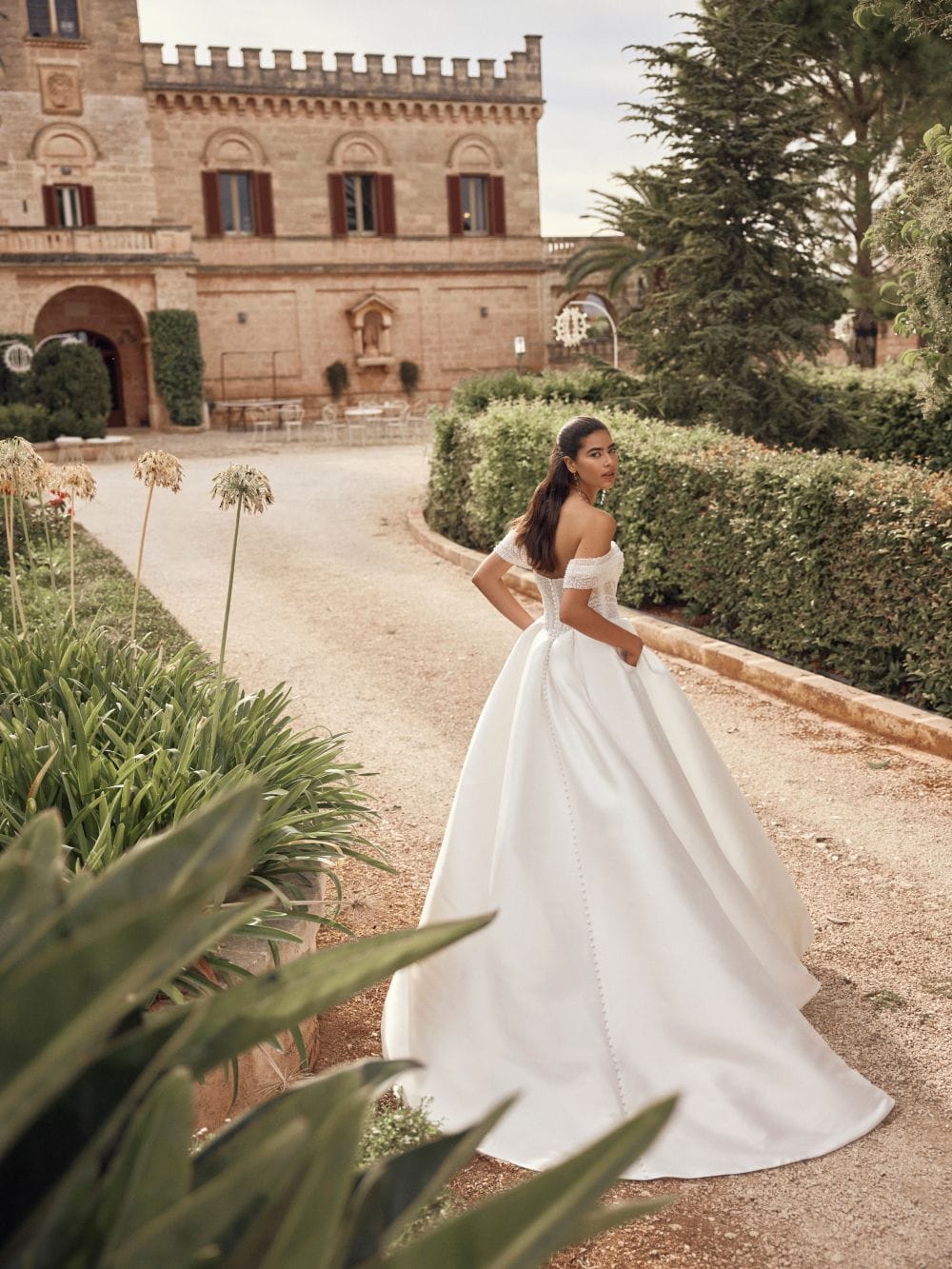 Breathtaking ballgown Melinda wedding dress by Modeca with plain full skirt and off the shoulder beaded basque bodice back view.