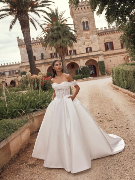 Breathtaking ballgown Melinda wedding dress by Modeca with plain full skirt and off the shoulder beaded basque bodice front view.